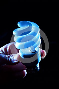 Hand holding cfl blue light-bulb lamp