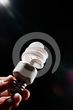 Hand holding cfl light-bulb lamp