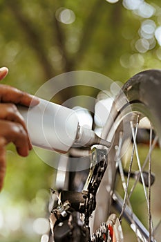 Hand holding chain lubricant for bicycle
