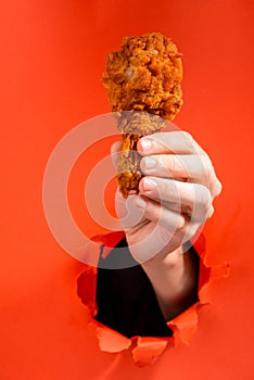 Hand holding a chicken drumstick