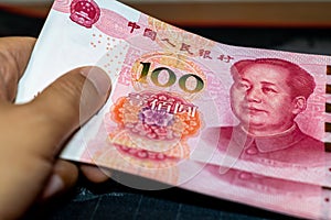 Hand holding Chinese yuan banknotes.