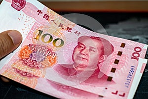 Hand holding Chinese yuan banknotes.