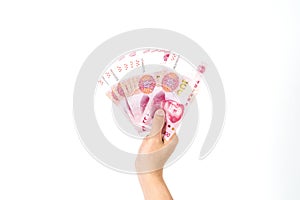 Hand holding Chinese yuan banknotes on white background.