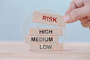 Hand holding chooses wooden block cubes with risk word. Risk management concept