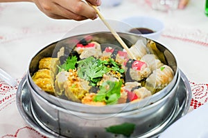 Hand holding chopsticks for eating mixed chinese steamed.