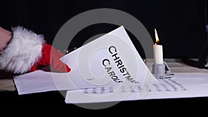 Hand holding Christmas carols music song sheet by candlelight