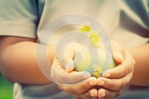 Hand holding clay globe model with seeding plant for save world in sunny day, Green World Environment ecology day, Life on earth