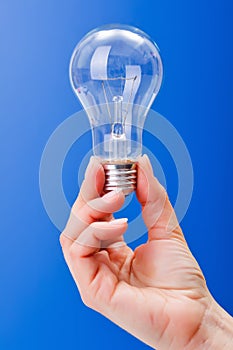 Hand holding a clear incandescent light bulb