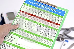 Hand holding clipboard with blank patient first admission form