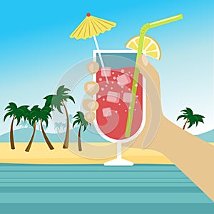 Hand holding cocktail with icecubes, straw and umbrella over tropical beach photo