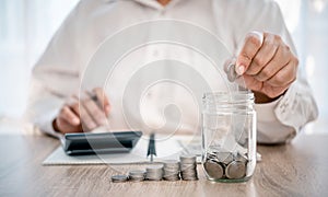 Hand holding coin with pig piggy bank. Saving and financial accounts concept