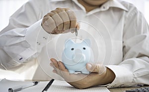 Hand holding coin with pig piggy bank. Saving and financial accounts concept