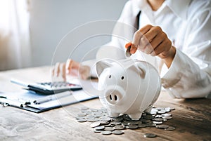 Hand holding coin with pig piggy bank. Saving and financial accounts concept