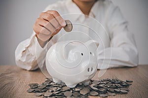 Hand holding coin with pig piggy bank. Saving and financial accounts concept