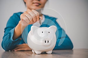 Hand holding coin with pig piggy bank. Saving and financial accounts concept