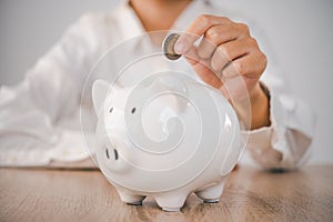 Hand holding coin with pig piggy bank. Saving and financial accounts concept