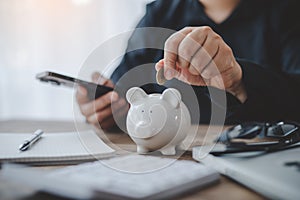 Hand holding coin with pig piggy bank. Saving and financial accounts concept