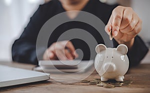 Hand holding coin with pig piggy bank. Saving and financial accounts concept