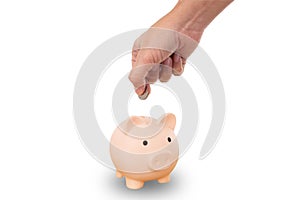 Hand holding a coin to put in the pink pigy bank, isolated on white background