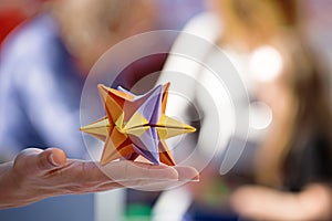 Hand holding a colorful and beautiful modular origami star