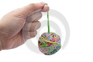 Hand holding colorful multi color elastic rubber bands ball isolated on white