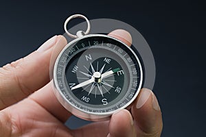 Hand holding compass, business or economy direction, world exploration or decision concept photo