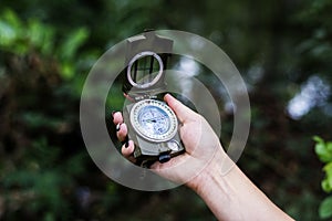 Hand holding a compass into the sky