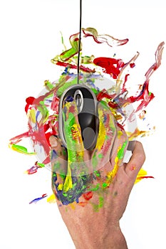 Hand holding a computer mouse with paint all around