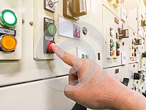 Hand holding the control panel of the industrial plant and pushing or turning the button in electrical selector switch,button