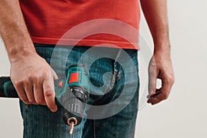 Hand holding cordless drill. Handyman with a tool screwdriwer drill