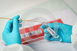 Hand holding COVID-19 swab collection kit, specimen sample testing process photo