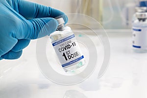 Doctor holding Coronavirus vaccine bottle with the name of first dose of the covid vaccine on the label