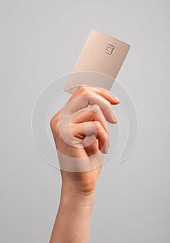 Hand holding credit card mockup with chip. Buying at stores, making transactions at terminals. Secure payments