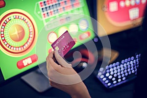 Hand holding credit card playing online gambling