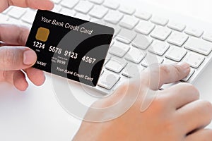 Hand holding a credit card and typing.