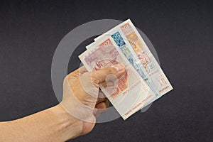 Hand holding Croatian KUNA or STO KUNA bank notes on black background.