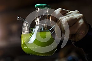 Hand holding a cruet containing extra virgin olive oil