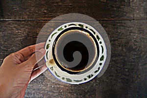 a hand holding a cup of coffee