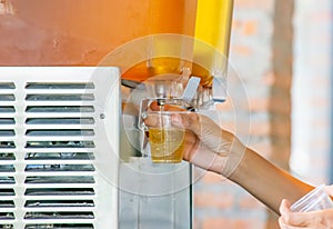 The hand holding the cup plastic flush tea from Juice Dispensor