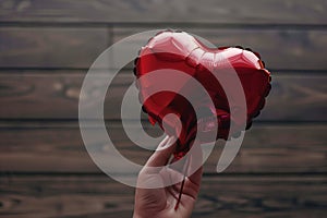 hand holding a deflated heartshaped balloon