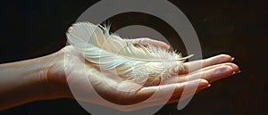 Hand holding a delicate feather depicting lightness photo