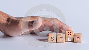 Hand holding Dice with text for illustration of `Stop or Step` words