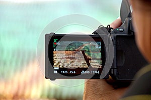 Hand holding the Digital camera, shoot of landscape photo using liveview