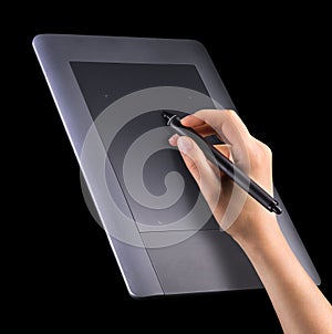 Hand holding digital graphic pen and drawing graphic tablet isolated on black