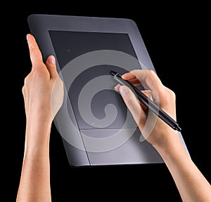 Hand holding digital graphic pen and drawing graphic tablet isolated on black