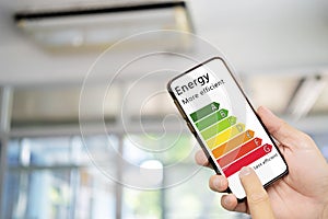 Hand holding digital smartphone and looking at house efficiency rating