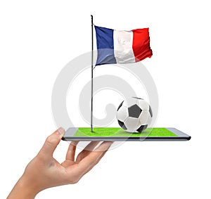 Hand holding digital tablet pc with soccer ball and French flag