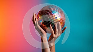 Hand holding disco ball on colored gradient background