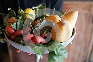 Hand holding dish with mango lemon, Indian ivy-rue Zanthoxylum Limonella