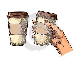 Hand holding a disposable cup of coffee with cardboard holder and cap.
